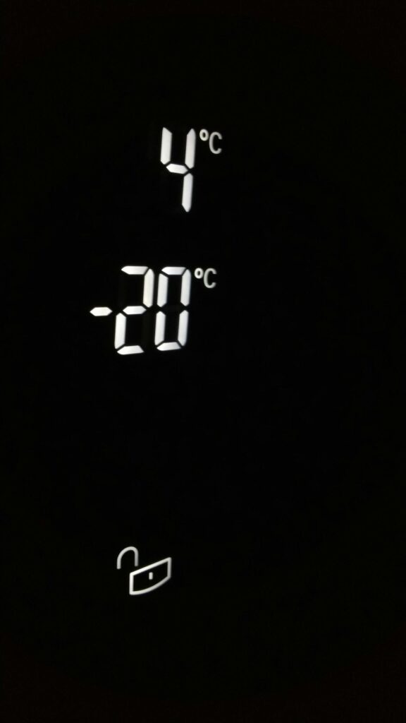 Close-up of electronic screen showing 4°C and -20°C in white digits