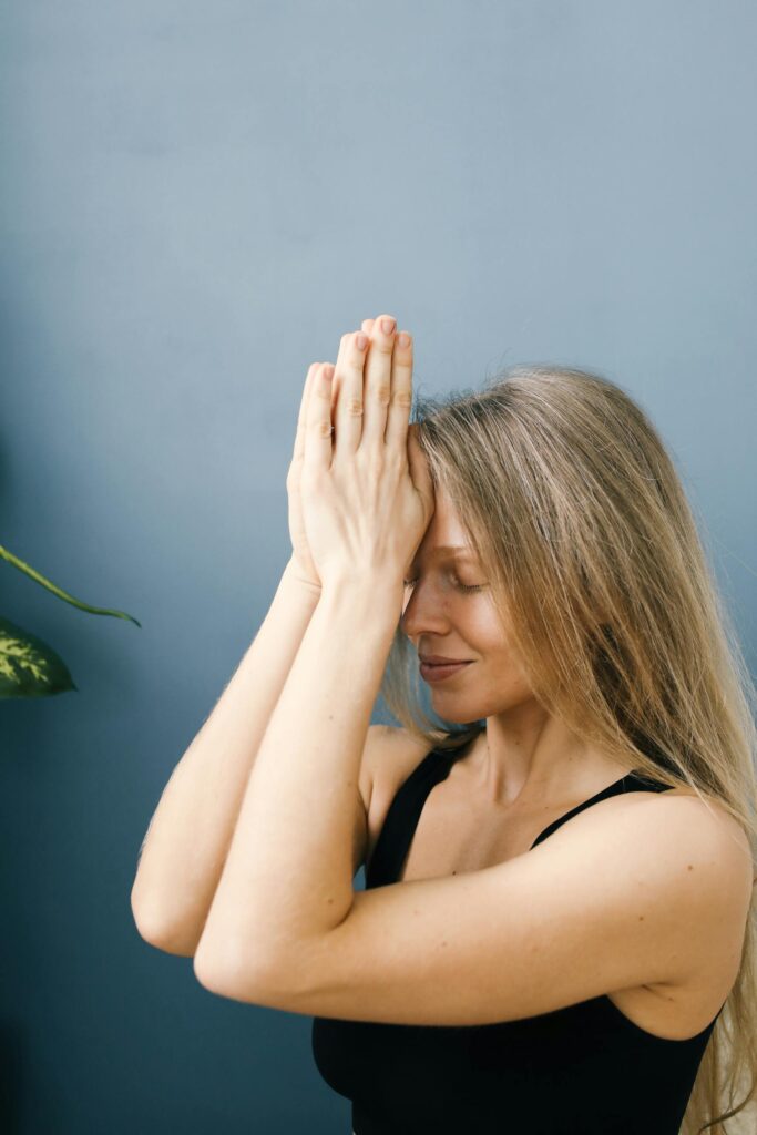 A serene woman in a meditation pose indoors, embracing spirituality and mindfulness.